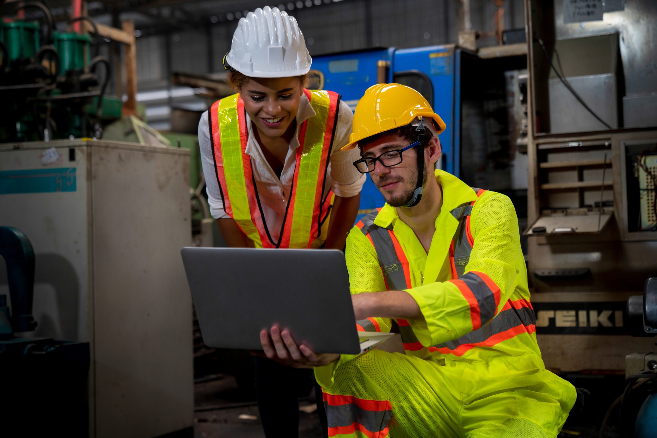 Professional engineers and technicians are inspecting machine operations via a laptop computer.